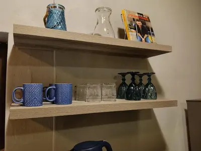 a wooden shelf with blue mugs and vases on it at Cozy Corner Cottage near wilgers hospital & Menlyn in Pretoria