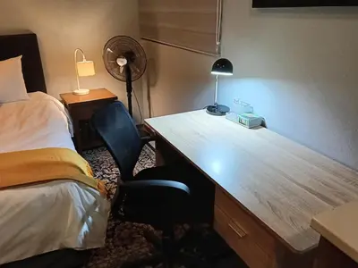 a desk in a hotel room with a bed and a deskictericter at Cozy Corner Cottage near wilgers hospital & Menlyn in Pretoria