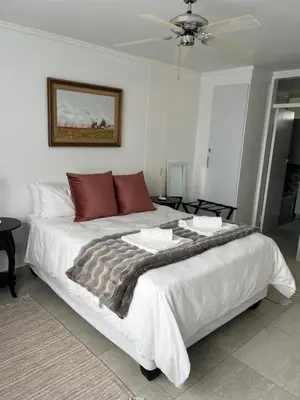 a bedroom with a large white bed with red pillows at 458 on Manitoba in Pretoria