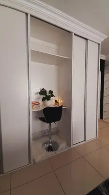 a glass wall with a desk and a chair at Palma Spaces in Pretoria