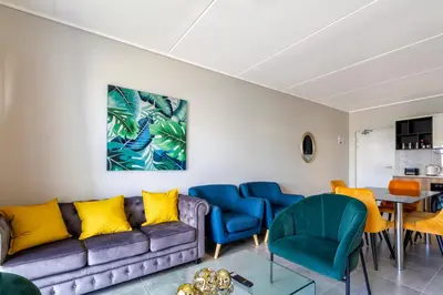 a living room with a couch and chairs at #AlimamaSpaces The Rob's Munyaka in Midrand