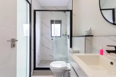a bathroom with a shower and a toilet and a sink at #AlimamaSpaces The Rob's Munyaka in Midrand
