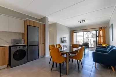 a kitchen and dining room with a table and chairs at #AlimamaSpaces The Rob's Munyaka in Midrand