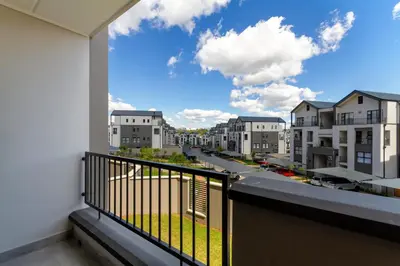 a balcony with a view of a street and buildings at #AlimamaSpaces The Rob's Munyaka in Midrand