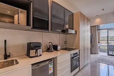 a kitchen with stainless steel appliances and a counter at 1606 Menlyn Maine Residence Luxury Apartments in Pretoria