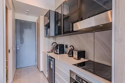 a kitchen with black cabinets and a counter top at 1606 Menlyn Maine Residence Luxury Apartments in Pretoria