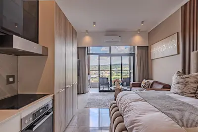 a bedroom with a large bed and a living room at 1606 Menlyn Maine Residence Luxury Apartments in Pretoria