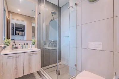 a bathroom with a glass shower and a sink at 1606 Menlyn Maine Residence Luxury Apartments in Pretoria