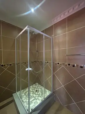 a shower with a glass enclosure in a bathroom at Homely Palace in Midrand