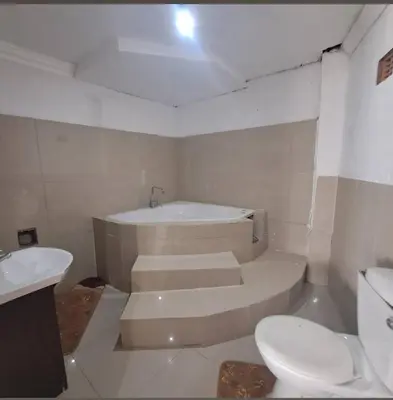 a bathroom with a tub and a toilet and a sink at Aquamarine Guesthouse in Mabopane