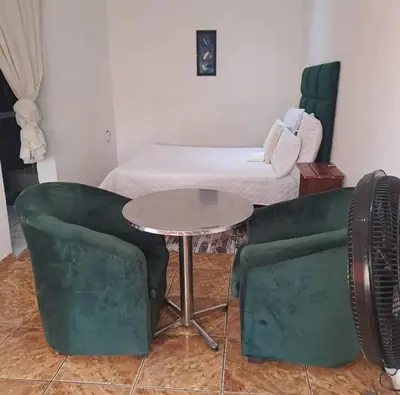 a room with a table and two chairs and a bed at Aquamarine Guesthouse in Mabopane