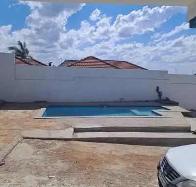 a swimming pool in the backyard of a house at Aquamarine Guesthouse in Mabopane