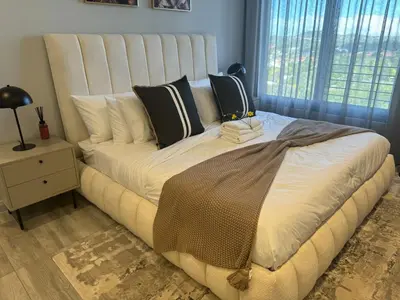 a large bed in a bedroom with a window at Stylish Dante Trilogy Menlyn Maine Apartment in Pretoria