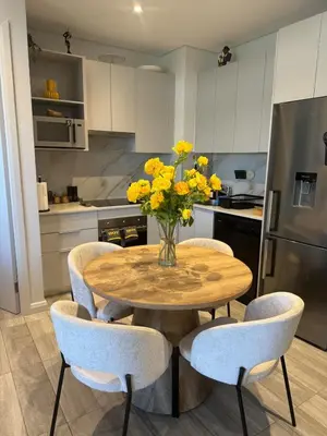 a kitchen with a table with yellow flowers on it at Stylish Dante Trilogy Menlyn Maine Apartment in Pretoria