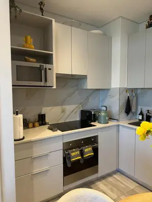 a kitchen with white cabinets and a stove top oven at Stylish Dante Trilogy Menlyn Maine Apartment in Pretoria