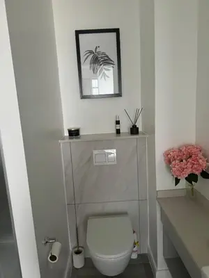 a bathroom with a toilet and a picture on the wall at Stylish Dante Trilogy Menlyn Maine Apartment in Pretoria