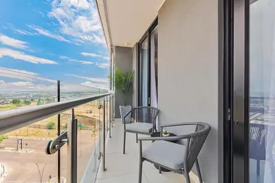 a balcony with two chairs and a table at Premium Urban Retreat at Ellipse Waterfall in Midrand