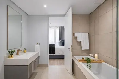 a bathroom with a sink and a tub and a bed at Premium Urban Retreat at Ellipse Waterfall in Midrand
