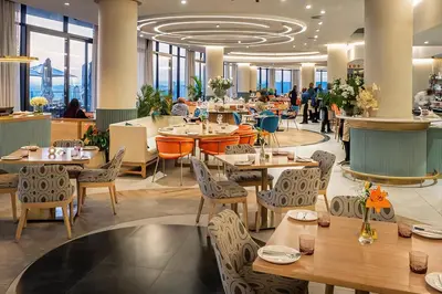 a restaurant with tables and chairs and people in the background at Premium Urban Retreat at Ellipse Waterfall in Midrand