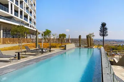 a large swimming pool next to a building at Premium Urban Retreat at Ellipse Waterfall in Midrand