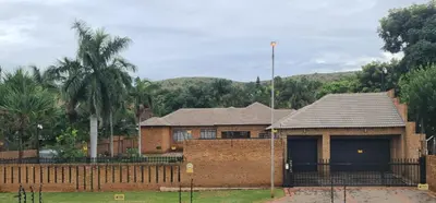 a brick house with a fence in front of it at A Pearl Place in Pretoria