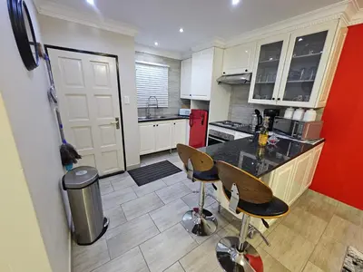 a kitchen with a counter and two bar stools at A Pearl Place in Pretoria