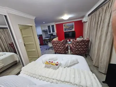 a hotel room with a bed and a dining room at A Pearl Place in Pretoria