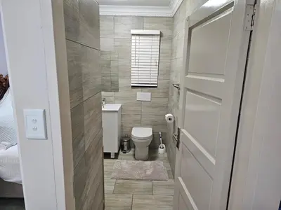 a small bathroom with a toilet and a window at A Pearl Place in Pretoria