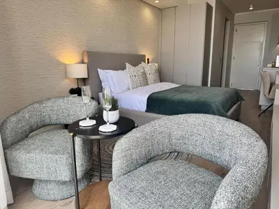 a hotel room with two chairs and a bed at Ellipse Waterfall in Midrand