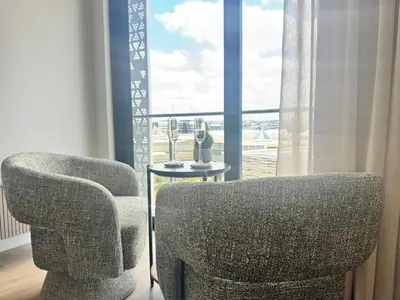 a living room with a chair and a table and a window at Ellipse Waterfall in Midrand