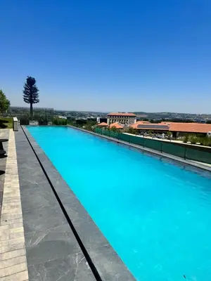a swimming pool with blue water on top of a building at Ellipse Waterfall in Midrand