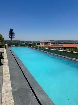 a swimming pool with blue water on a building at Ellipse Waterfall in Midrand