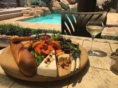 a plate of food on a table with a glass of wine at Studio at 26 in Centurion