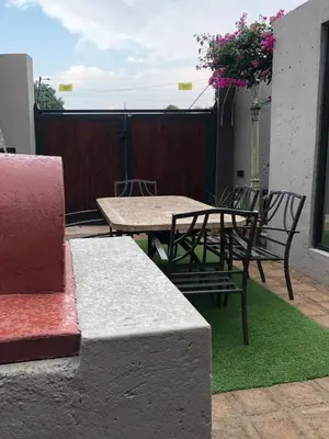 a patio with a table and chairs on a balcony at Studio at 26 in Centurion