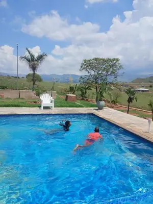 two people swimming in a swimming pool at JandJ Guest House in Armburg
