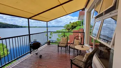 a screened in porch with a view of the water at Boathouse 203 in Hartbeespoort