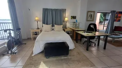 a bedroom with a bed and a desk and a bike at Boathouse 203 in Hartbeespoort