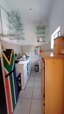 a small kitchen with white counters and white appliances at Boathouse 203 in Hartbeespoort