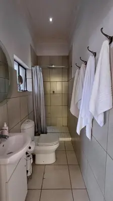 a bathroom with a toilet and a sink with towels at Boathouse 203 in Hartbeespoort