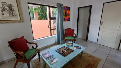 a living room with a table and chairs and a window at Boathouse 203 in Hartbeespoort