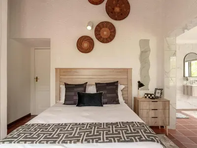 a bedroom with a bed and clocks on the wall at Thaba Metsi Private Game Lodge - Welgevonden in Vaalwater