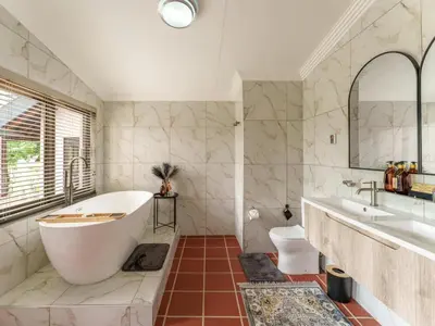 a bathroom with a tub and a sink at Thaba Metsi Private Game Lodge - Welgevonden in Vaalwater