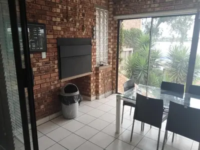 a patio with a table and chairs and a brick wall at Elephant hide away in Witbank
