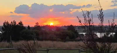 a sunset over a field with the sun setting at Elephant hide away in Witbank