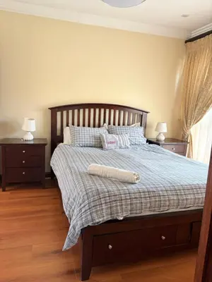 a bedroom with a bed with a wooden headboard at Lakeview Haven in Hartbeespoort