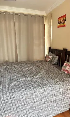 a bedroom with a bed with a checkered blanket at Lakeview Haven in Hartbeespoort