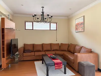 a living room with a brown couch and a table at Lakeview Haven in Hartbeespoort