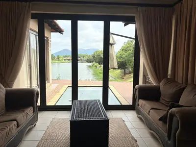 a living room with a view of a lake at Lakeview Haven in Hartbeespoort
