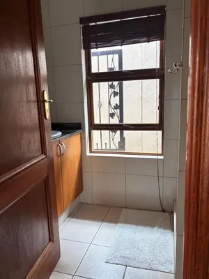 a bathroom with a window and a tiled floor at Lakeview Haven in Hartbeespoort