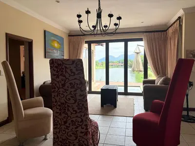 a living room with two chairs and a chandelier at Lakeview Haven in Hartbeespoort